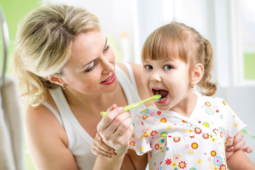 Parent brushing childs teeth